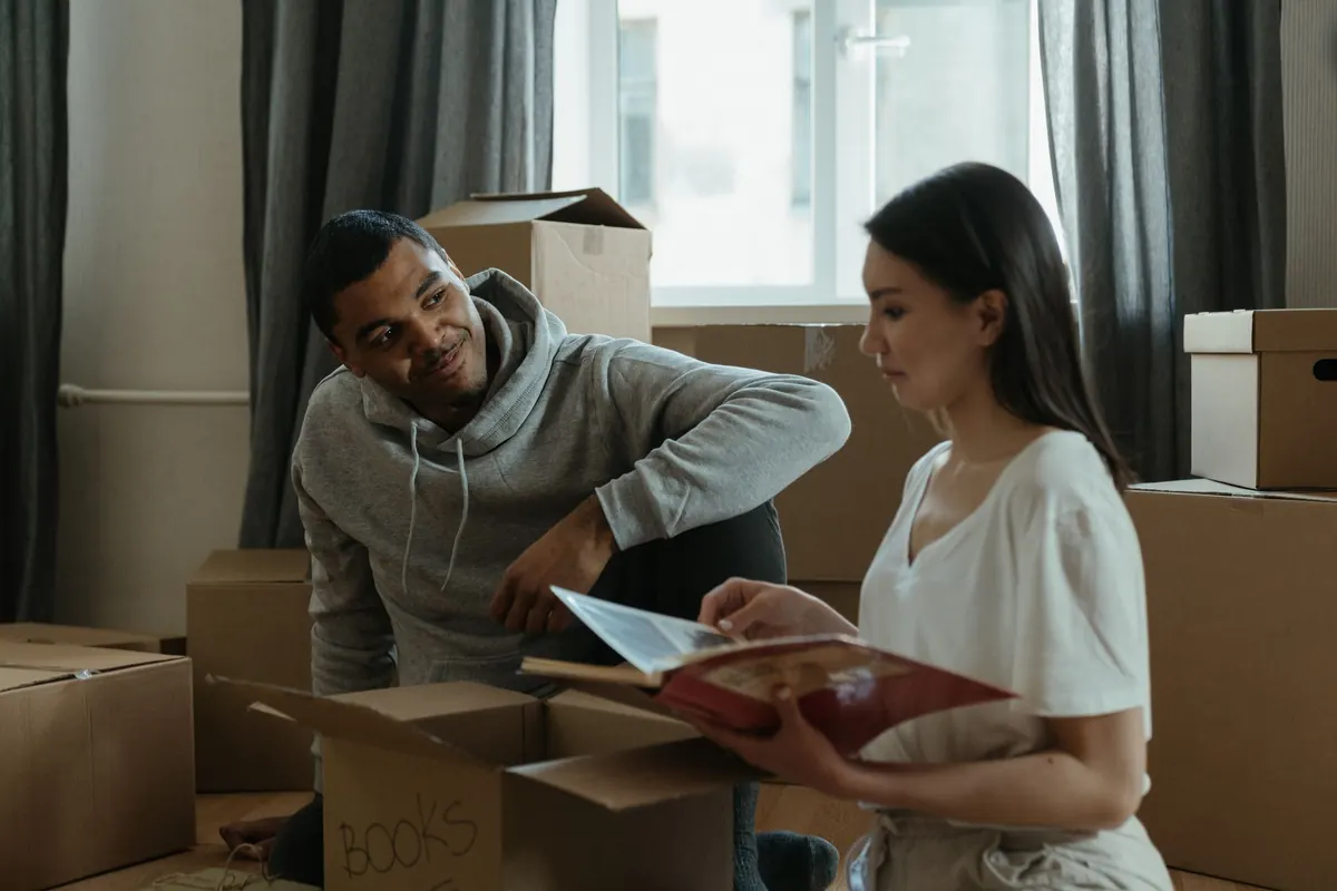 Casal organizando caixas de mudança no apartamento novo